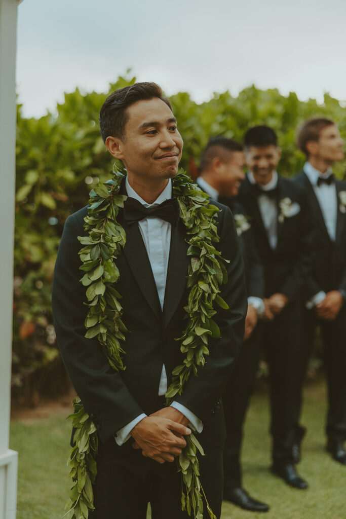 Outdoor wedding ceremony with palm trees and guests seated.
