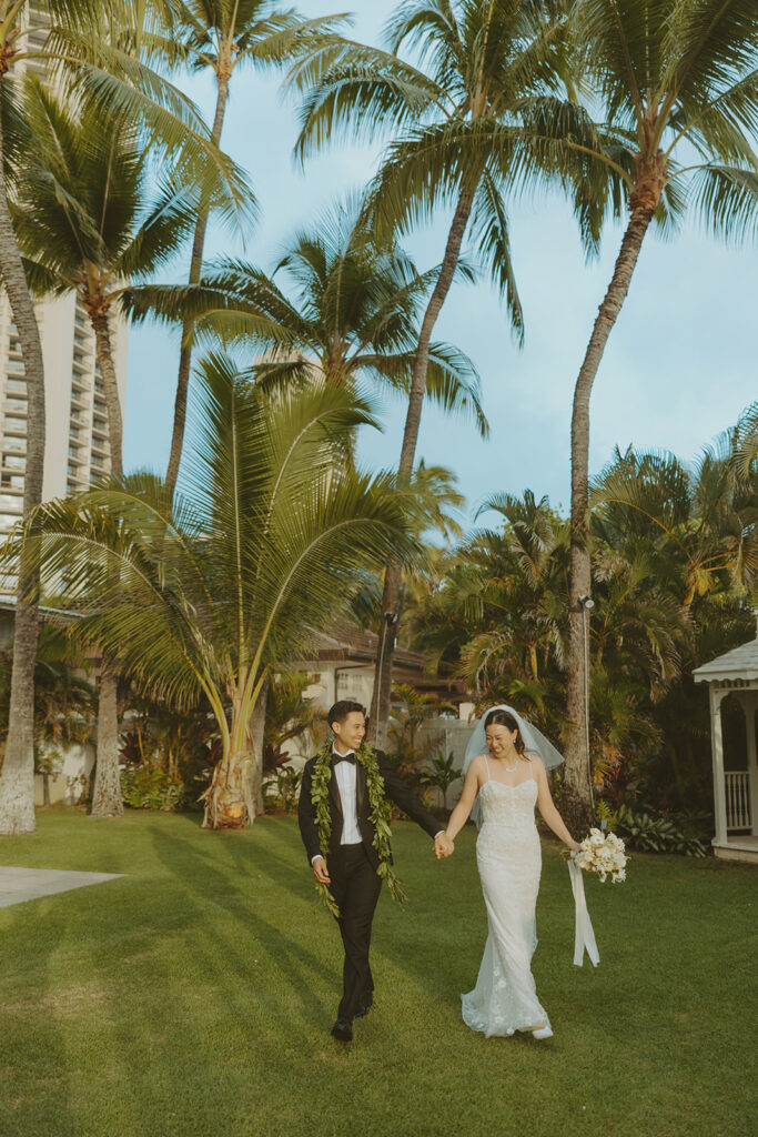 Bride holding a bouquet of white flowers on the beach.
