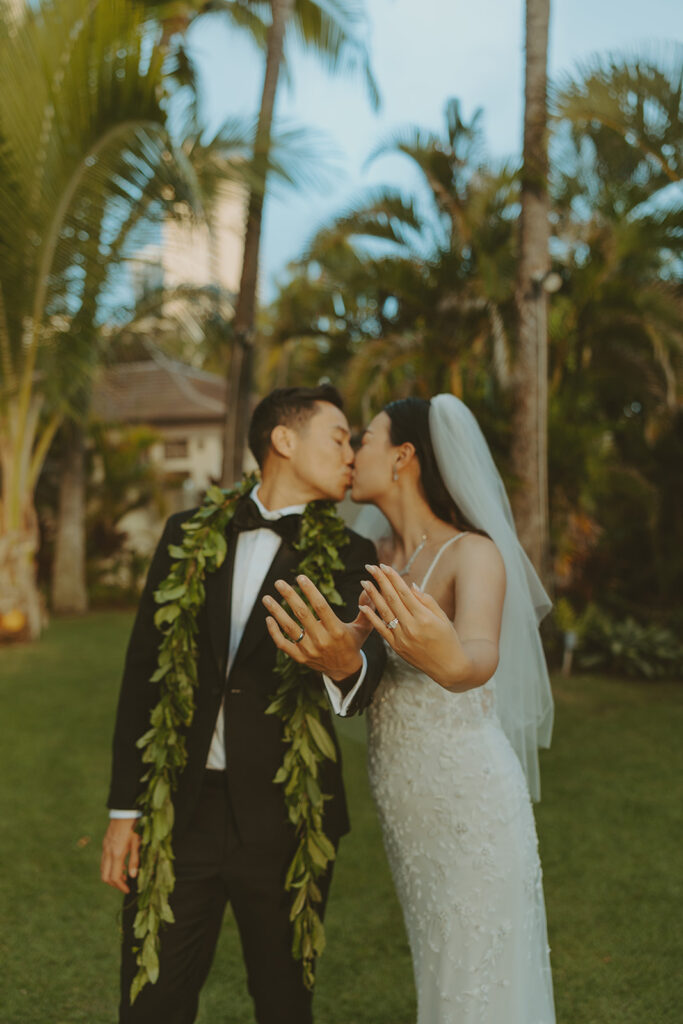 Bride holding a bouquet of white flowers on the beach.
