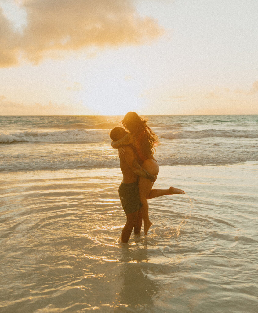 Couple holding hands and running along the beach during an Oahu couples photoshoot
