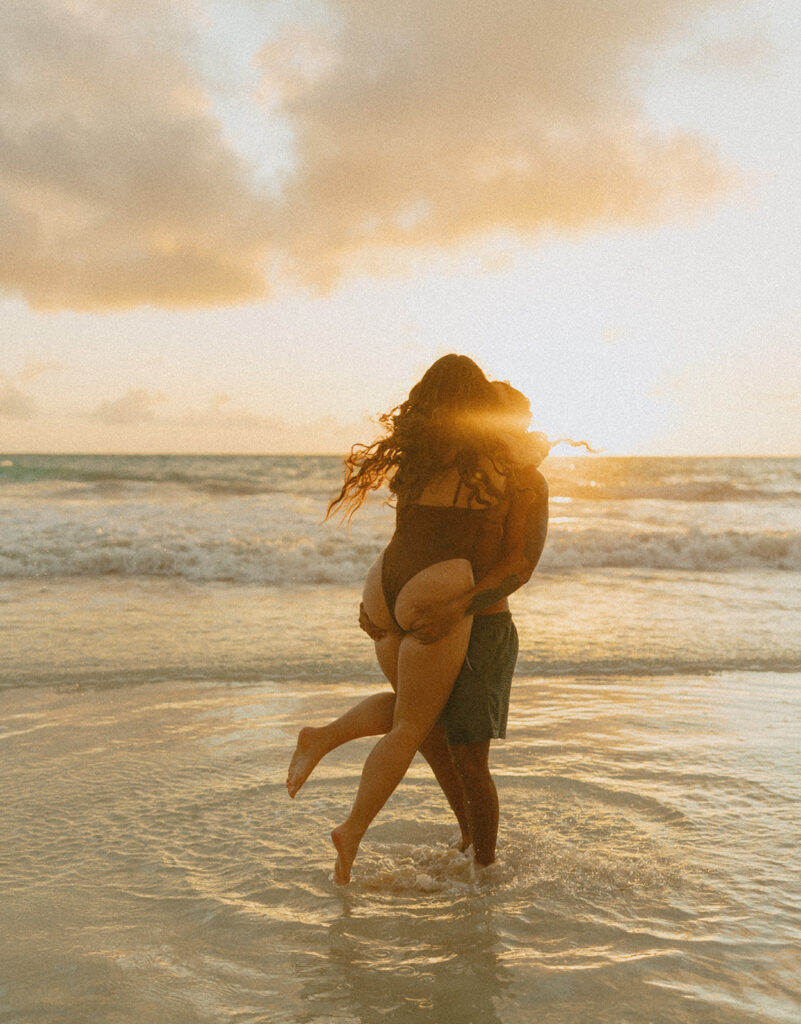 Couple holding hands and running along the beach during an Oahu couples photoshoot
