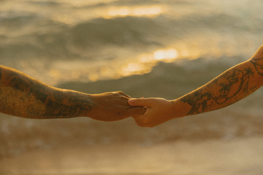 Romantic beach photoshoot with couple embracing in the waves in Hawaii
