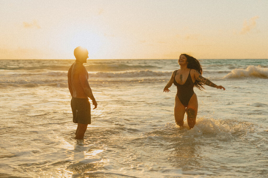 Romantic beach photoshoot with couple embracing in the waves in Hawaii
