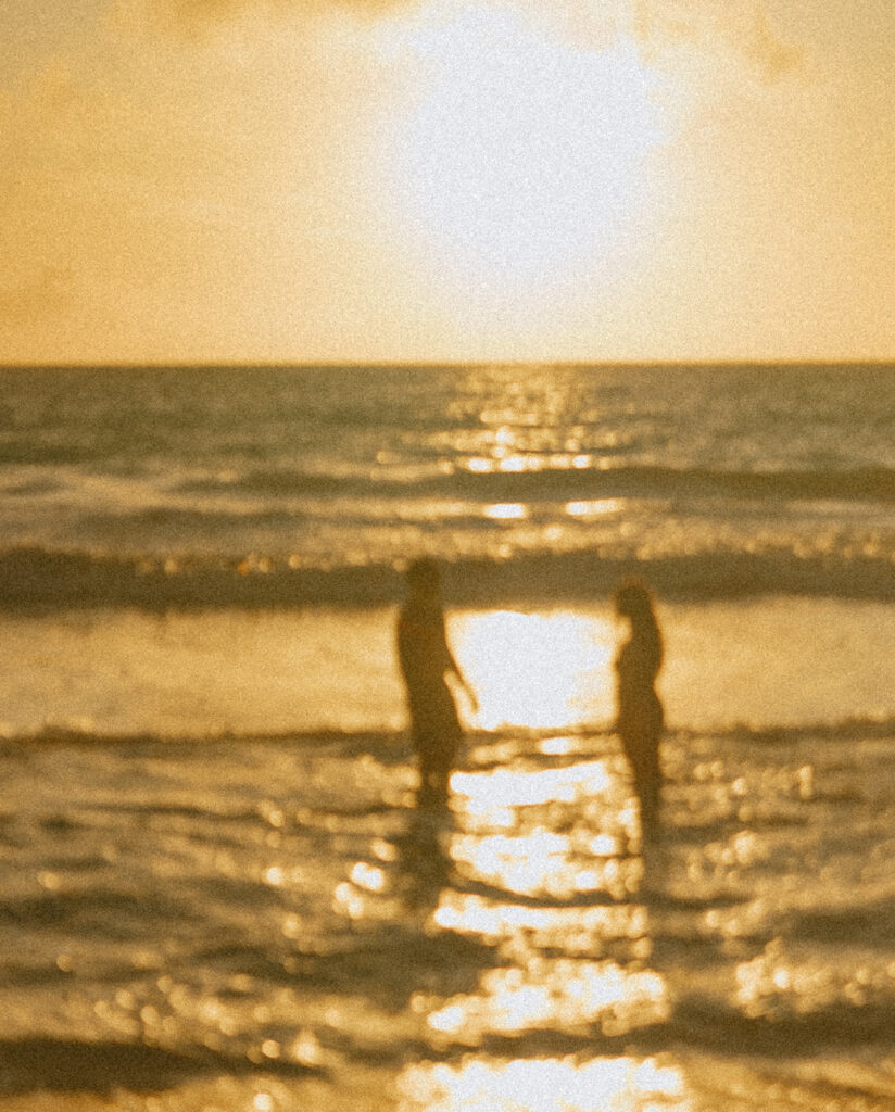 Romantic beach photoshoot with couple embracing in the waves in Hawaii
