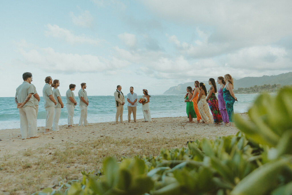 Bride and groom celebrating with their wedding party along the ocean shoreline.
North Shore Elopement in Oahu