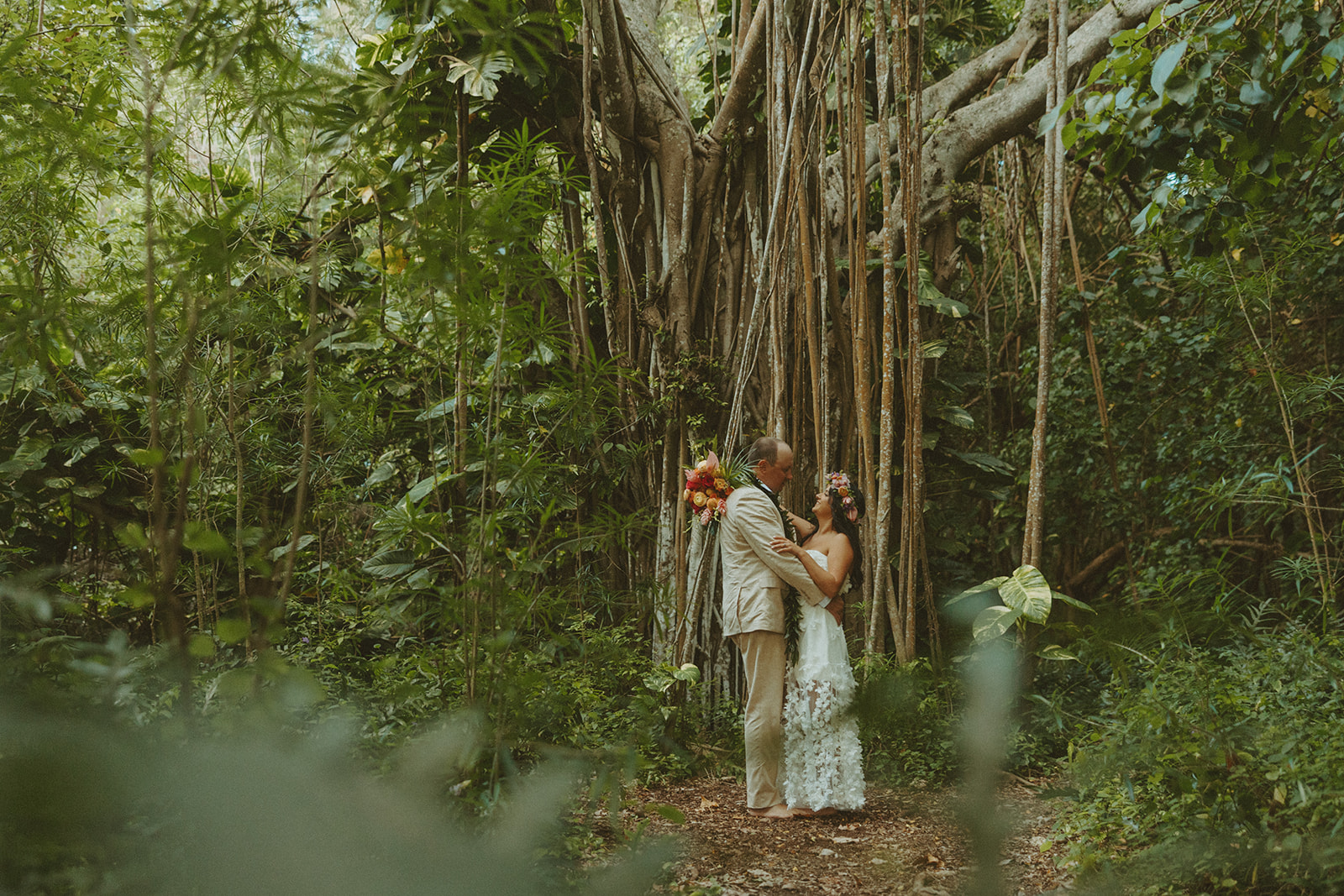 Romantic beach portraits of the couple surrounded by tropical scenery.