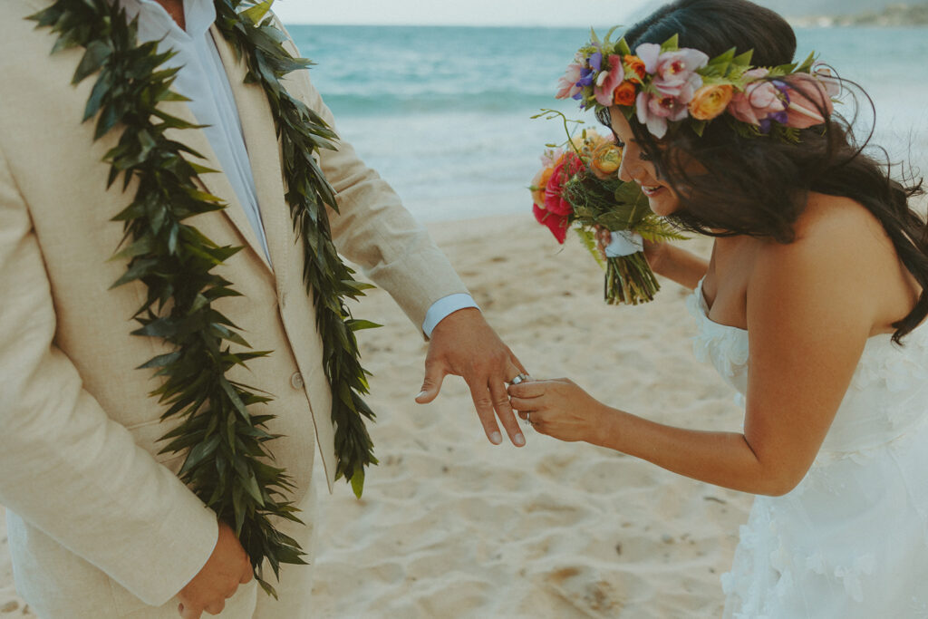 Bride and groom celebrating with their wedding party along the ocean shoreline.