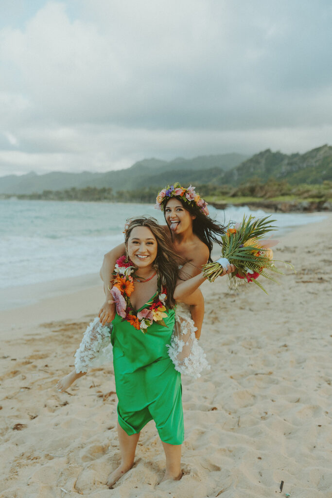 Bride and groom celebrating with their wedding party along the ocean shoreline.
