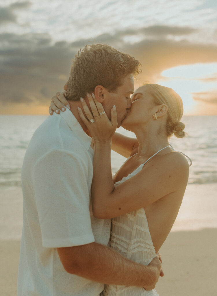 Romantic moment captured on the sand with ocean waves in the background
