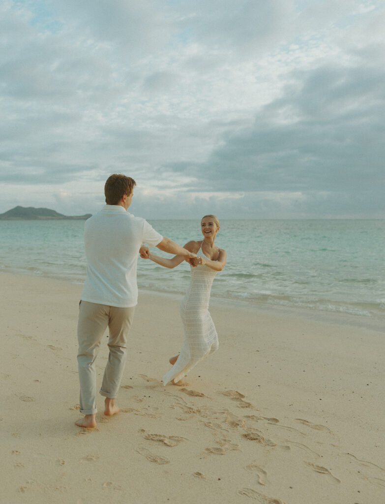 Couple embracing after a surprise proposal during golden hour by the water
 | Lanikai Beach Proposal