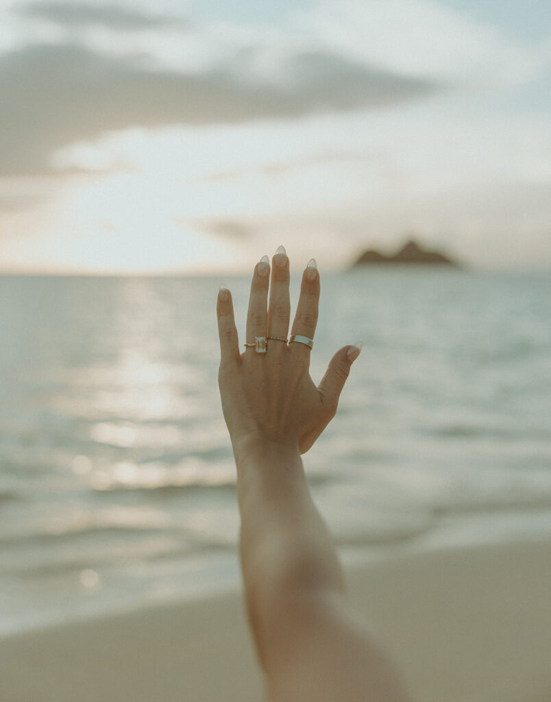 Couple embracing after a surprise proposal during golden hour by the water
