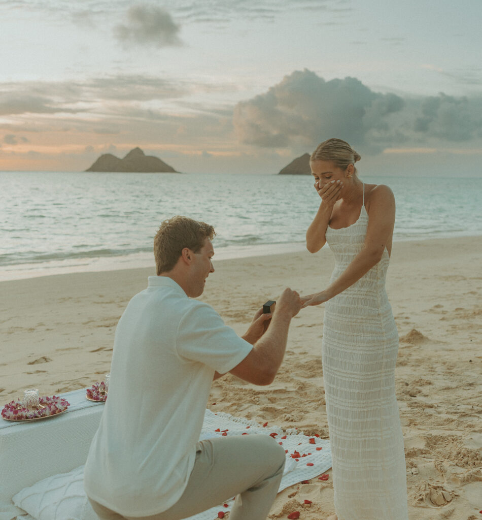 Couple sharing a sunrise picnic proposal on a quiet beach in Hawaii
 | Lanikai Beach Proposal
