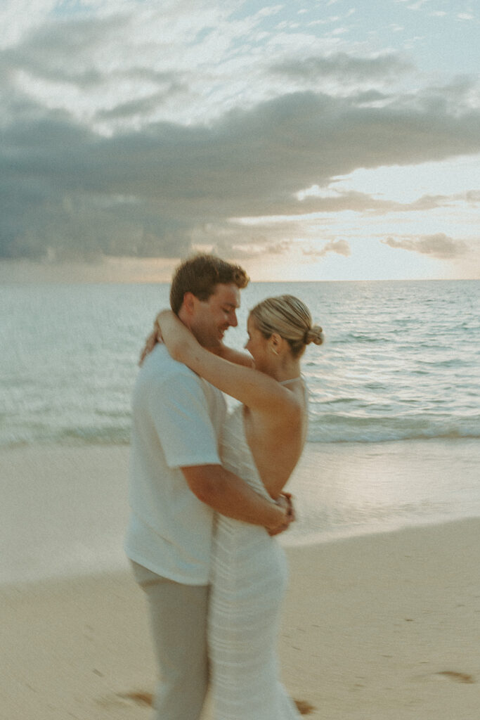 Romantic moment captured on the sand with ocean waves in the background | Lanikai Beach Proposal