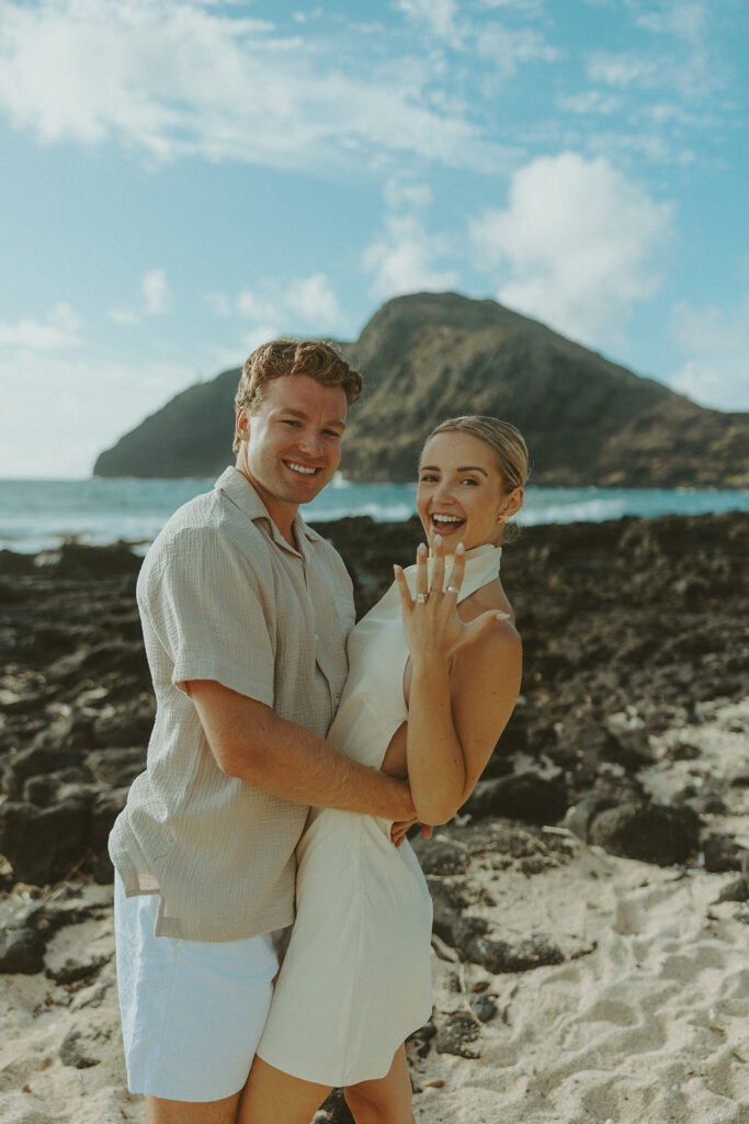 Romantic moment captured on the sand with ocean waves in the background
