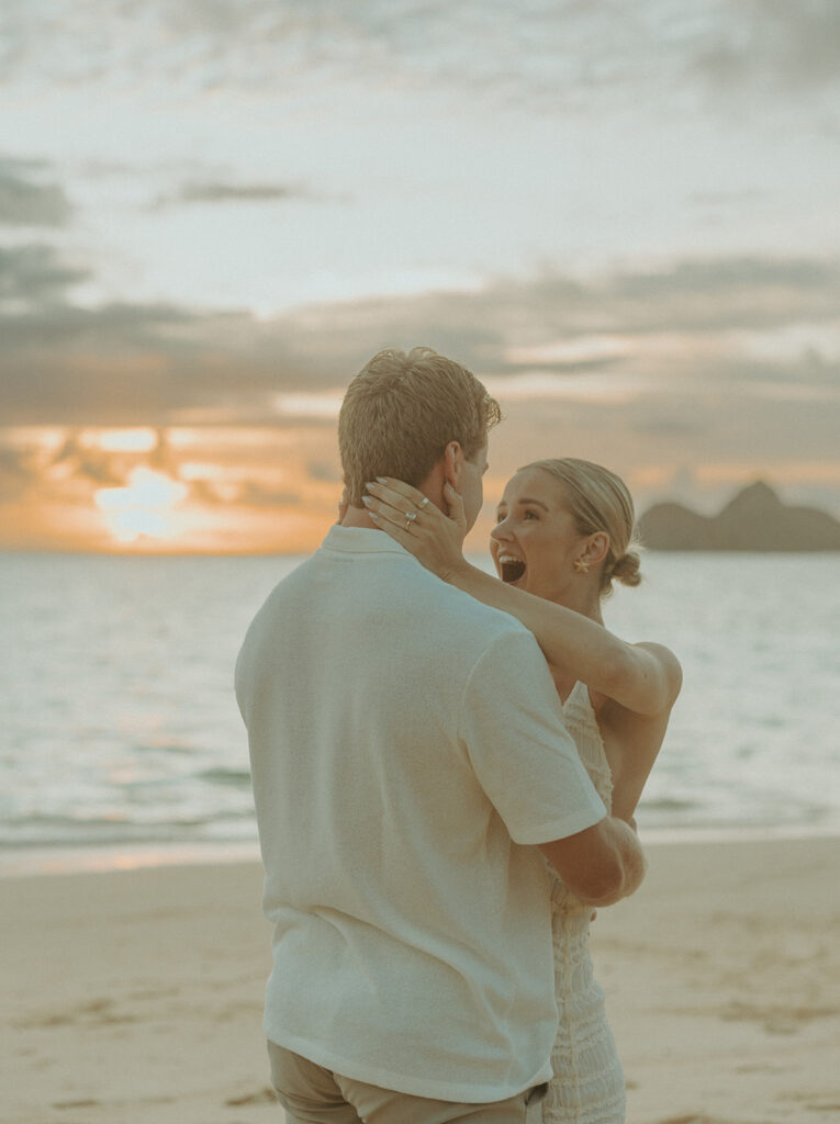 Couple sharing a sunrise picnic proposal on a quiet beach in Hawaii
