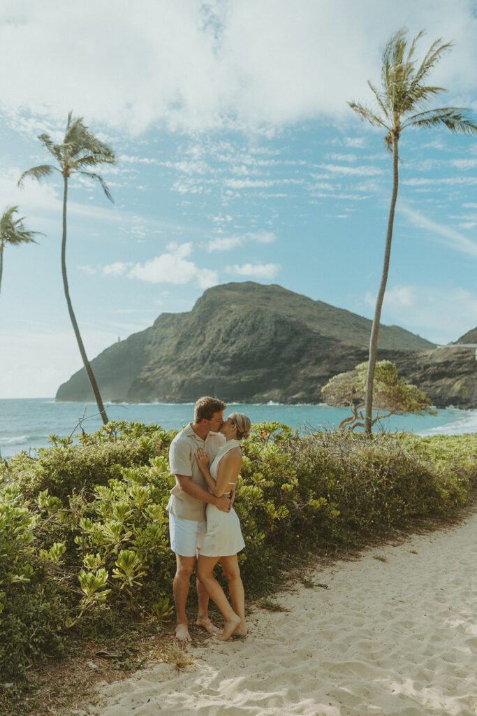 Romantic moment captured on the sand with ocean waves in the background