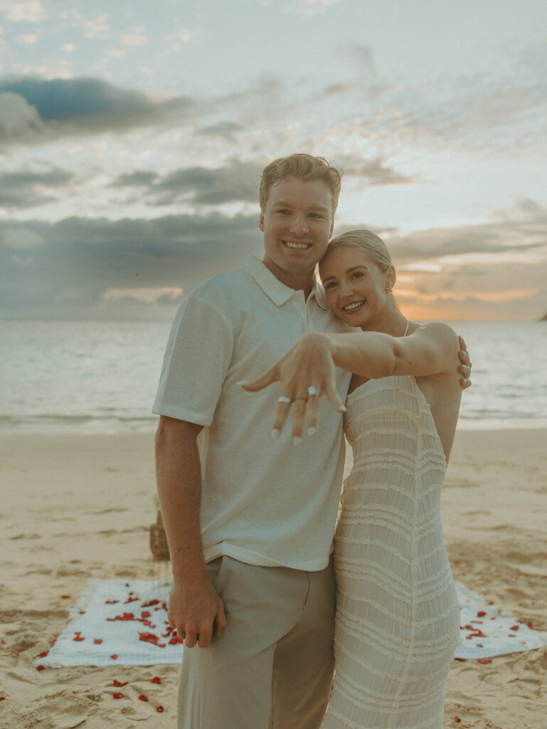 Couple sharing a sunrise picnic proposal on a quiet beach in Hawaii
