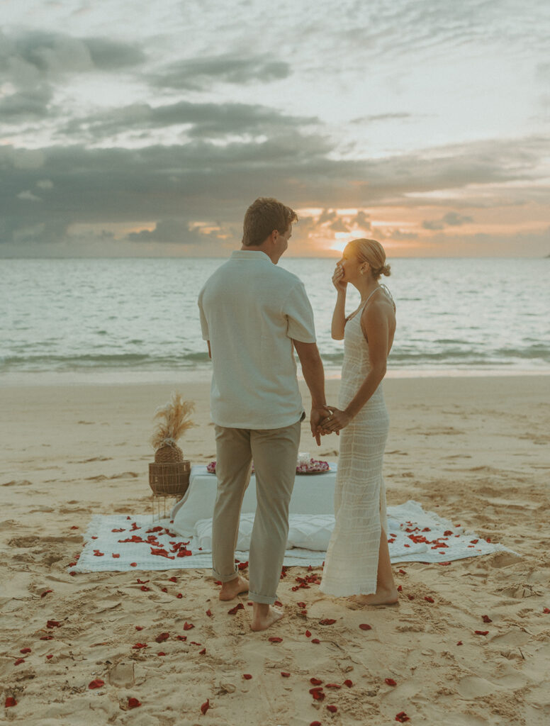Couple sharing a sunrise picnic proposal on a quiet beach in Hawaii
 | Lanikai Beach Proposal