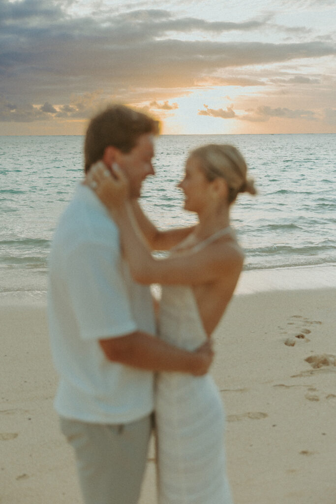 Romantic moment captured on the sand with ocean waves in the background
