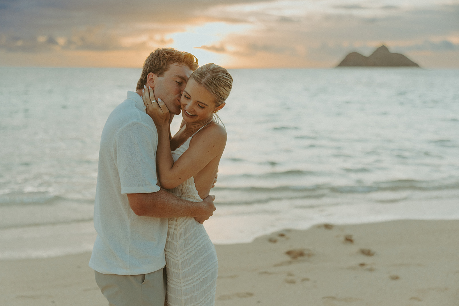 Romantic moment captured on the sand with ocean waves in the background
