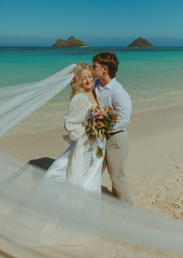 Couple standing on Lanikai Beach during their intimate elopement ceremony.
