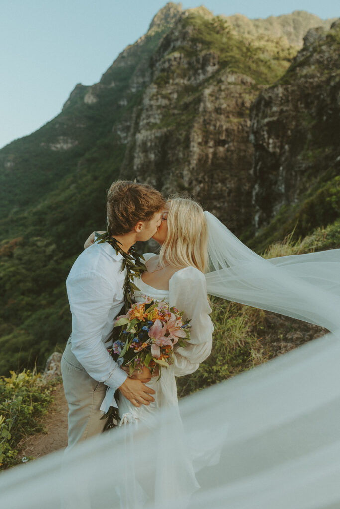 Couple hiking up the Crouching Lion trail surrounded by lush Oahu scenery.
