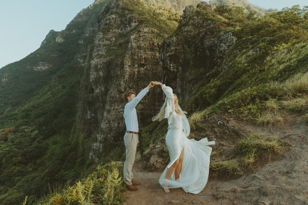 Couple hiking up the Crouching Lion trail surrounded by lush Oahu scenery.
