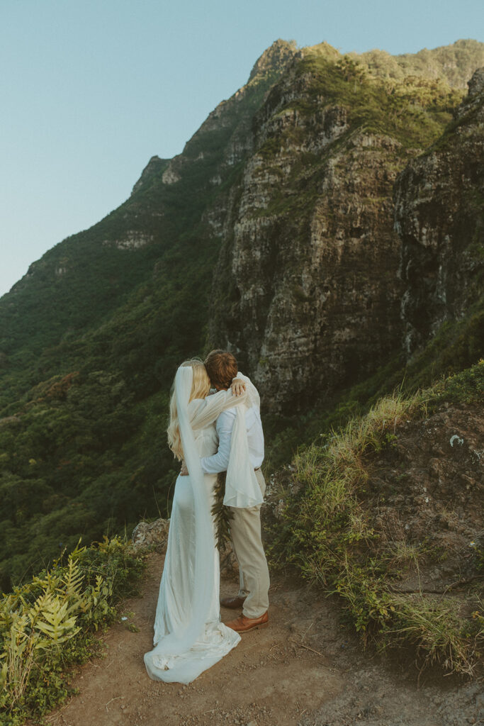 Couple hiking up the Crouching Lion trail surrounded by lush Oahu scenery.
