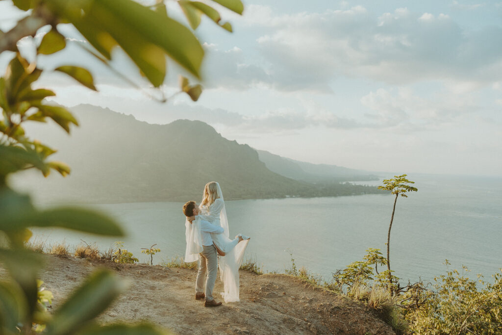Couple hiking up the Crouching Lion trail surrounded by lush Oahu scenery.
