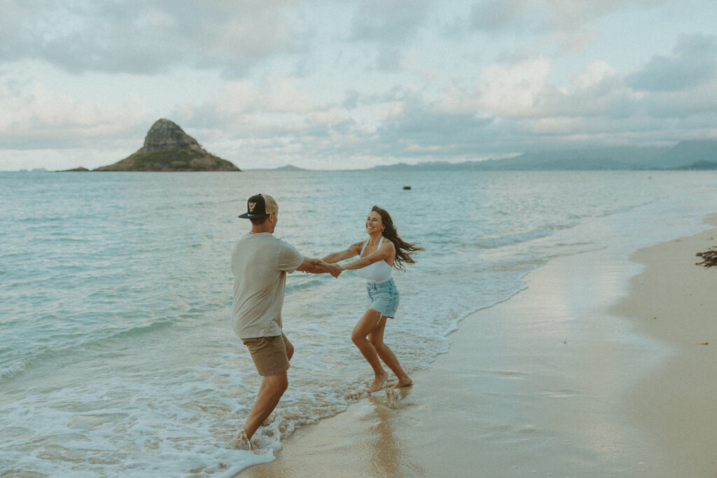 Couple enjoying a quiet moment by the ocean at Kualoa Regional Park in Hawaii
