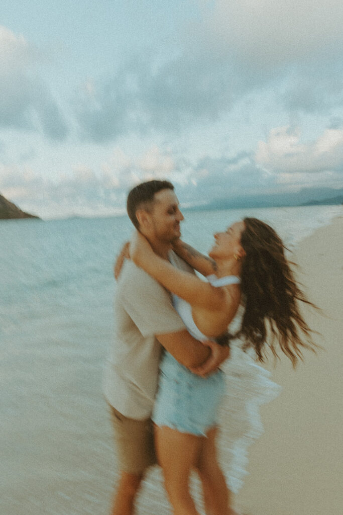 Couple enjoying a quiet moment by the ocean at Kualoa Regional Park in Hawaii
