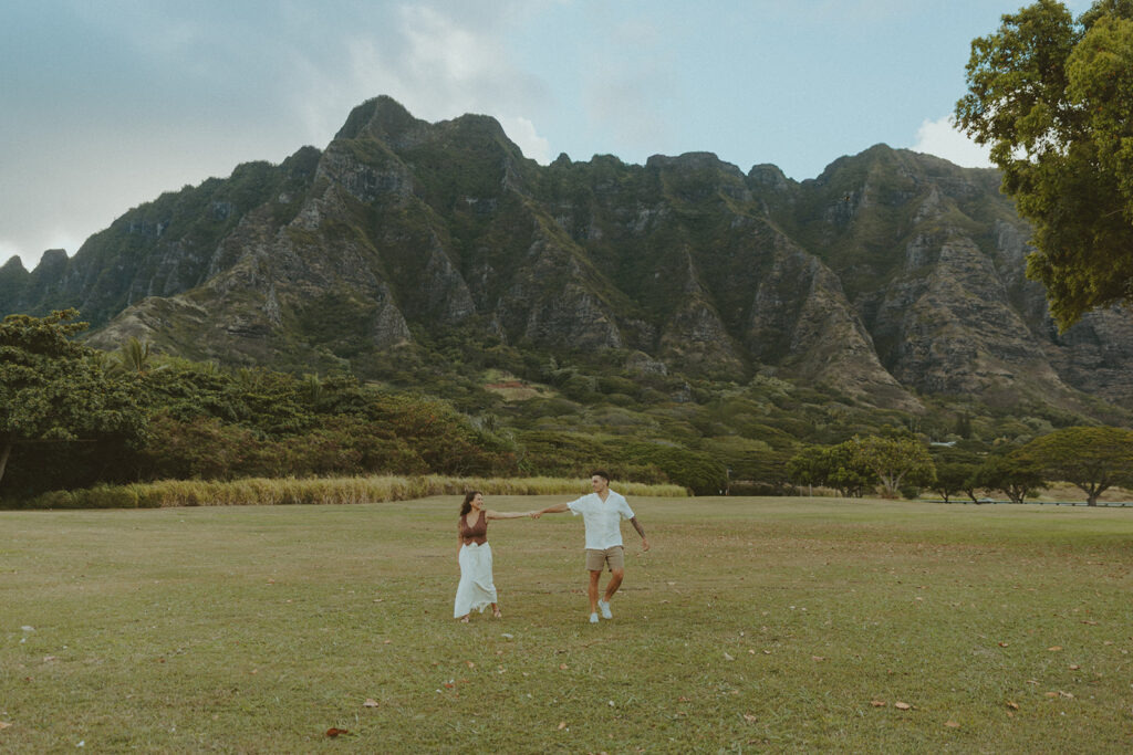 Husband and wife holding hands during a relaxed photo session at Kualoa Regional Park

