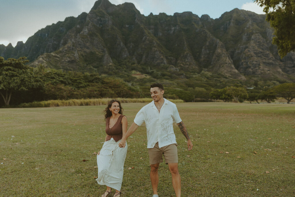 Husband and wife holding hands during a relaxed photo session at Kualoa Regional Park
