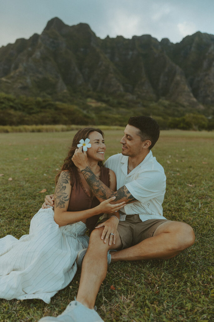 Couple walking along the shoreline at Kualoa Regional Park with ocean and mountain views in the background