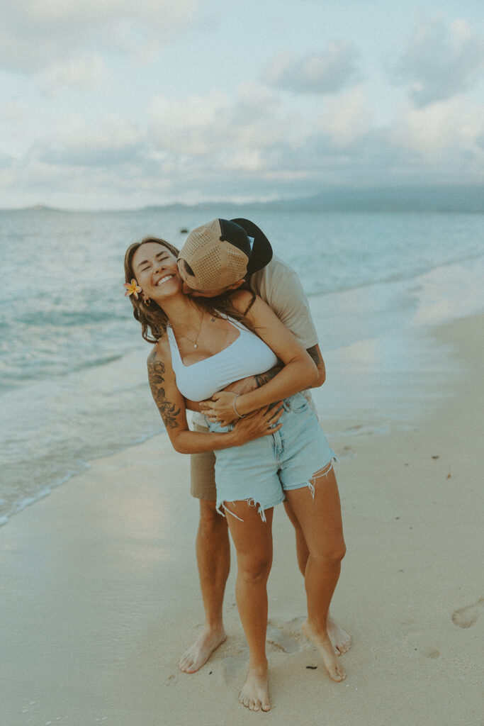 Couple enjoying a quiet moment by the ocean at Kualoa Regional Park in Hawaii

