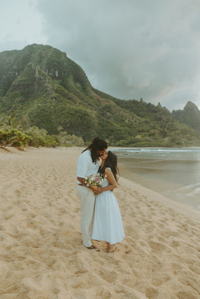 Candid engagement photos of a couple at Tunnels Beach in Kauai during golden hour