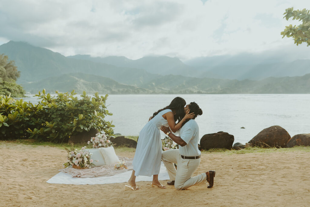 Romantic proposal setup with picnic details and flowers near the water at 1 Hotel Hanalei Bay