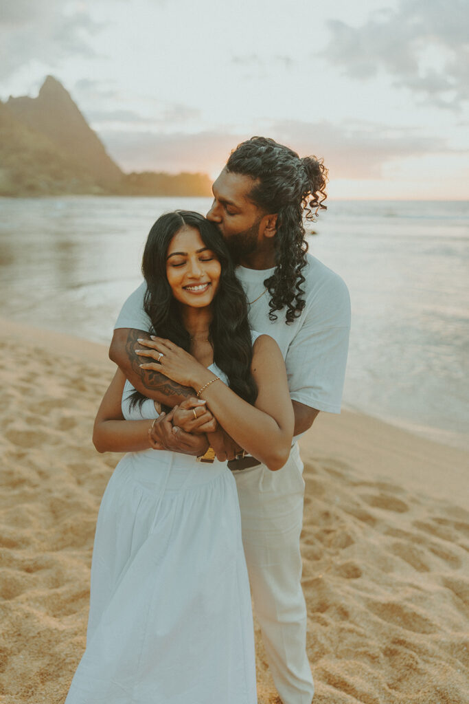 Sunset engagement session at Tunnels Beach with mountains, ocean waves, and a relaxed Hawaii vibe