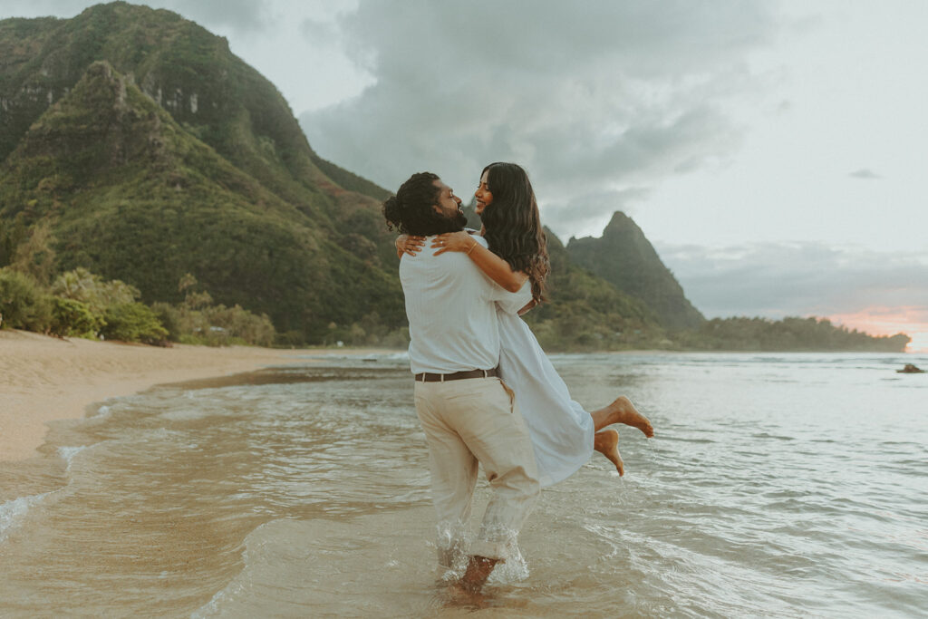 Couple walking along the shoreline at 1 Hotel Hanalei Bay on Kauai with ocean views and soft natural light