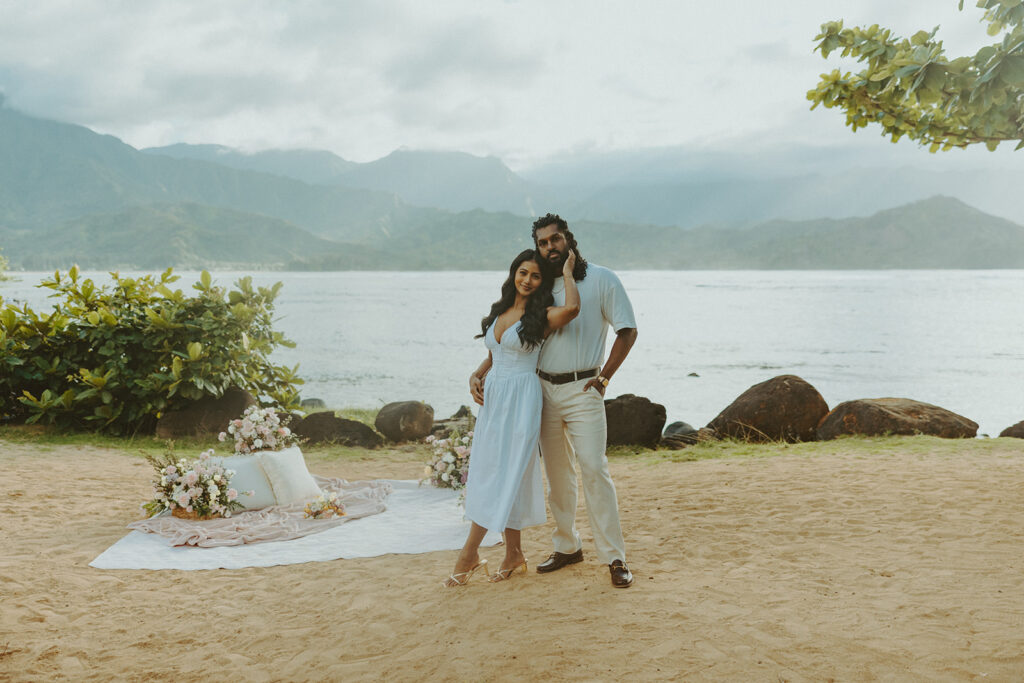 Romantic proposal setup with picnic details and flowers near the water at 1 Hotel Hanalei Bay