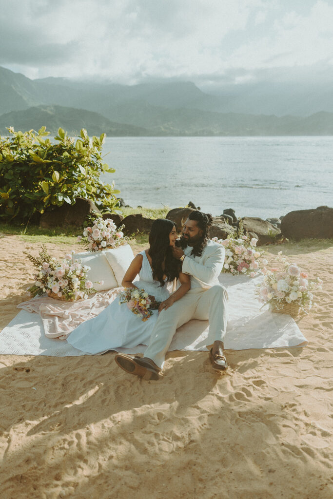 Romantic proposal setup with picnic details and flowers near the water at 1 Hotel Hanalei Bay