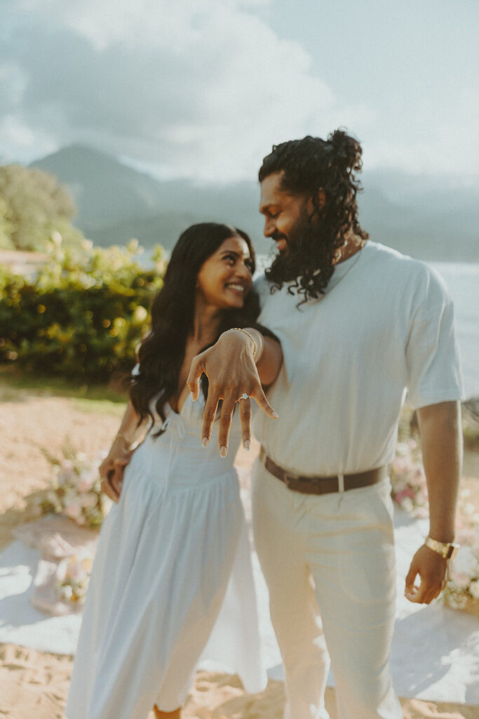 Candid engagement photos of a couple at Tunnels Beach in Kauai during golden hour