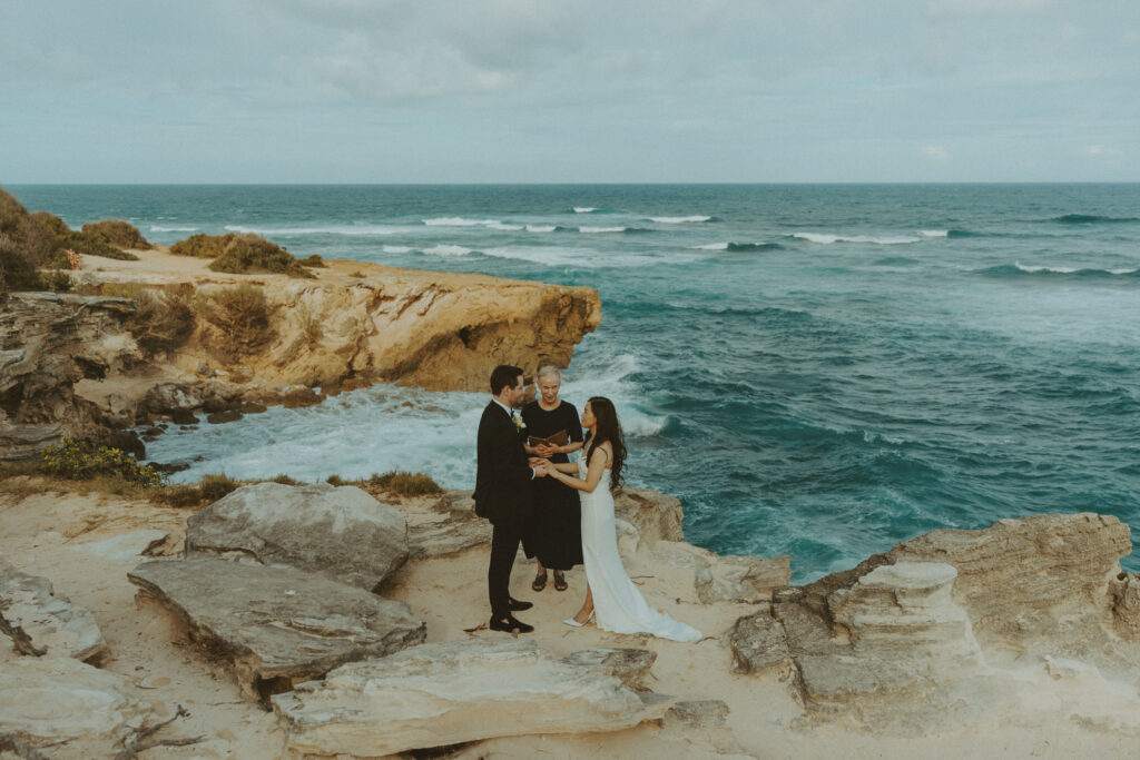 Couple exchanging vows on the cliffs during an intimate Hawaii elopement
