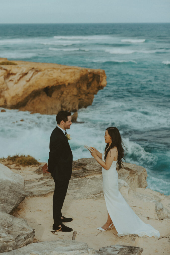 Couple exchanging vows on the cliffs during an intimate Hawaii elopement
