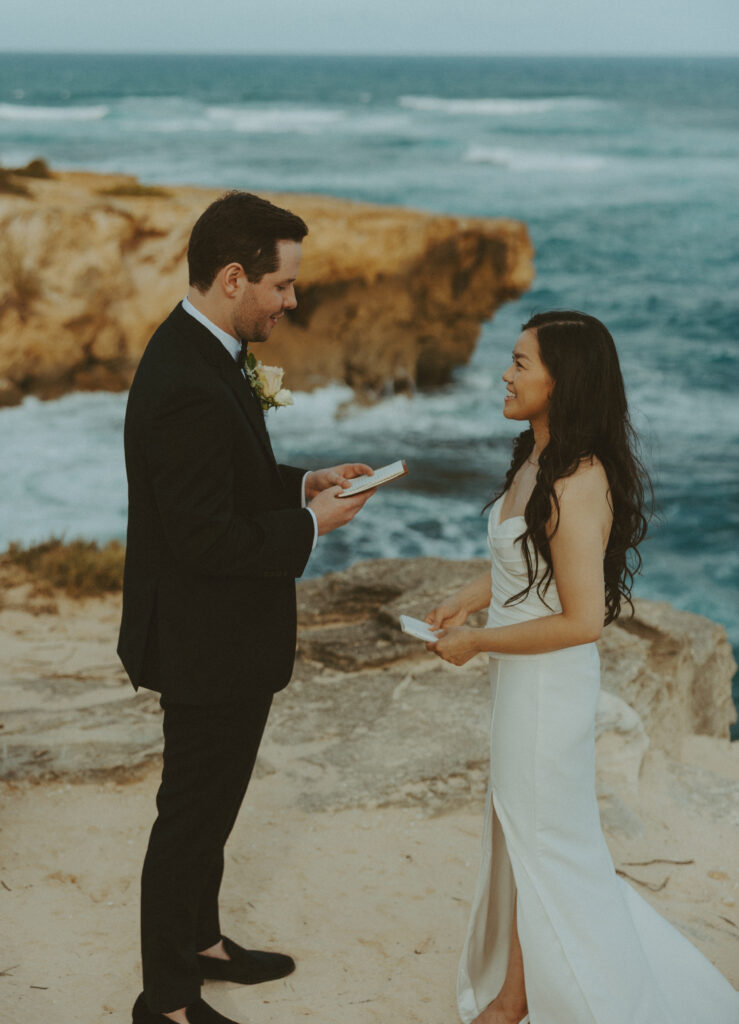 Couple exchanging vows on the cliffs during an intimate Hawaii elopement