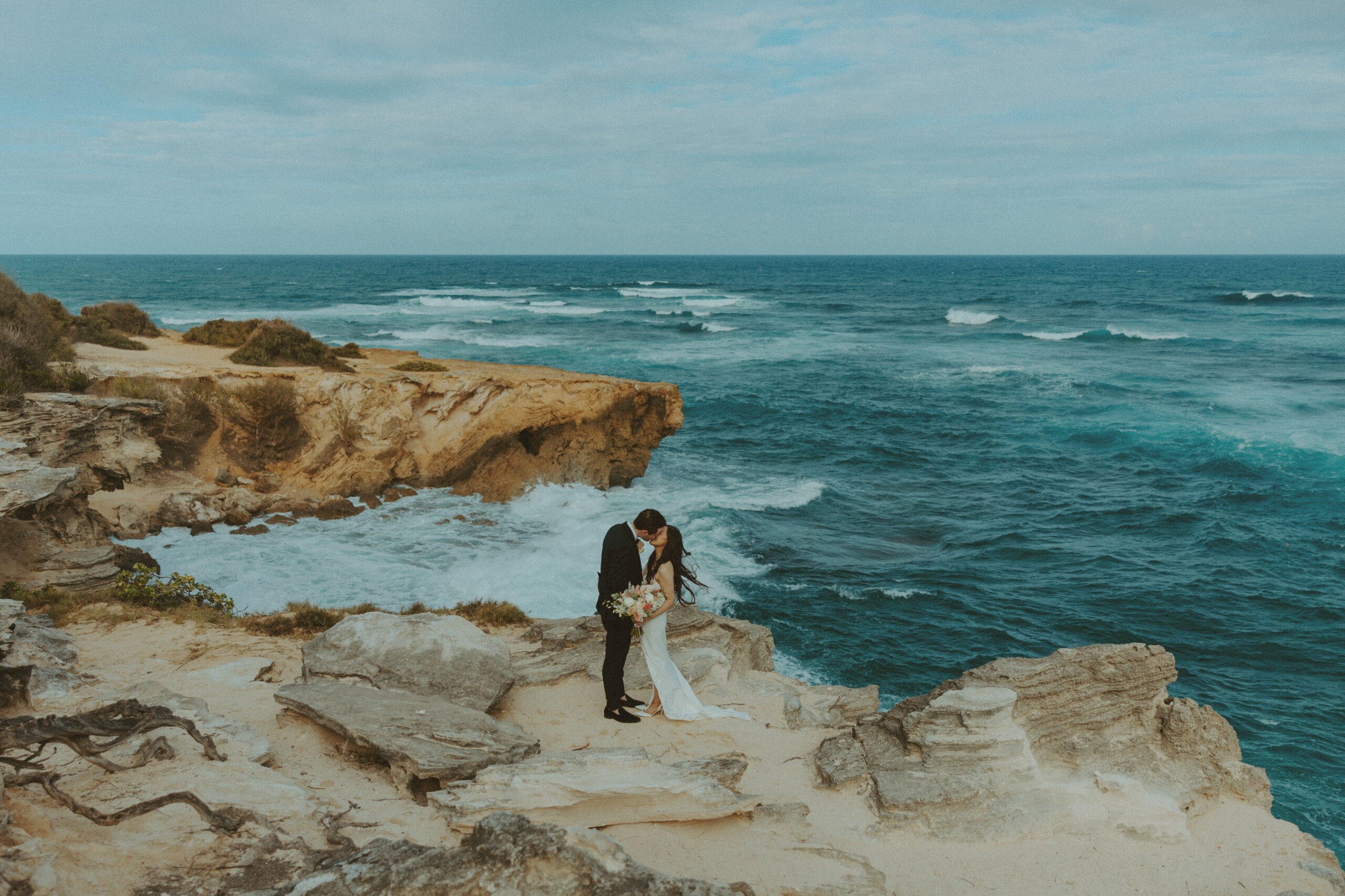 Couple exchanging vows on the cliffs during an intimate Hawaii elopement