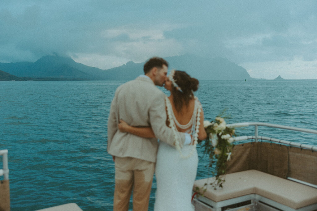 Bride and groom standing in shallow ocean water during a beach wedding ceremony