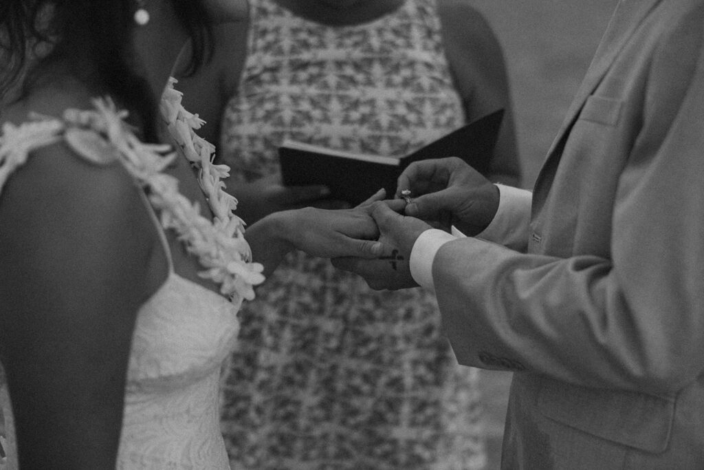 Bride and groom standing in shallow ocean water during a beach wedding ceremony
