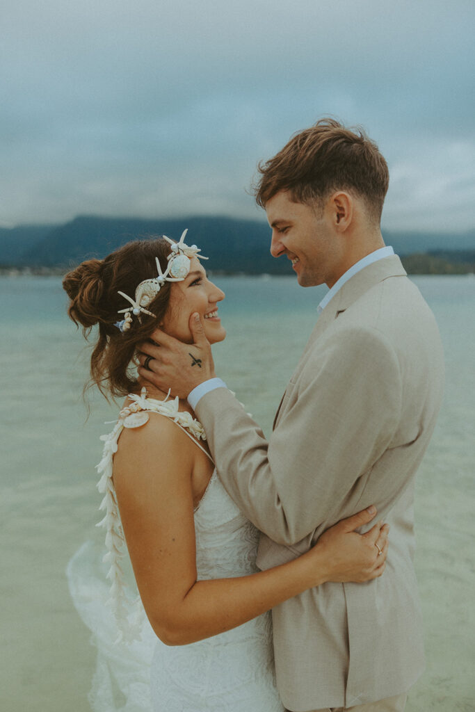Bride and groom standing in shallow ocean water during a beach wedding ceremony