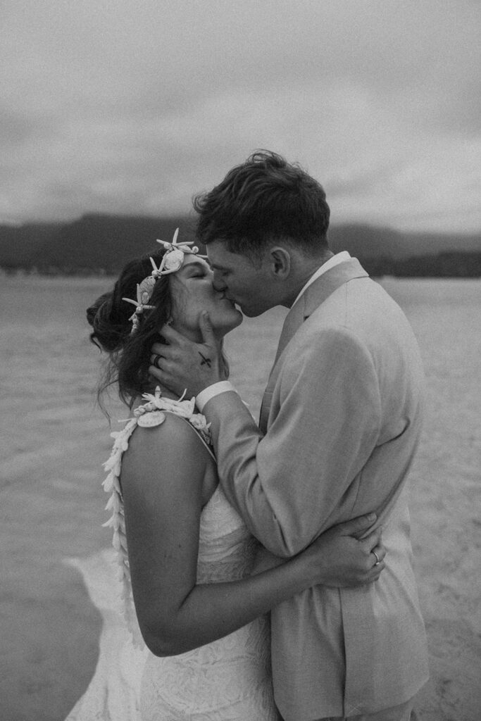 Couple holding hands in the water with mountains in the background